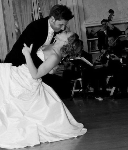 A groom dips a bride, dancing in front of the Twin Cities Hot Club jazz band
